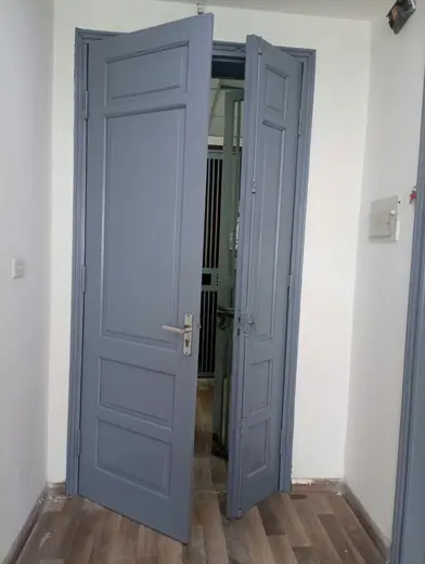 Hai cánh cửa gấp màu xám xanh mới sơn