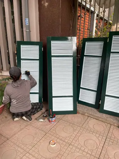 Thợ đang quét sơn lá sách khung xanh